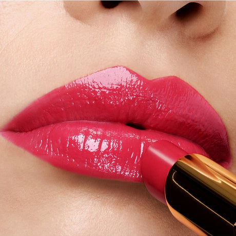 alt="A close-up of lips coated in vibrant rose-red lipstick with high-gloss finish, the saturated pigment precisely applied by a gold-accented bullet. Natural skin texture in soft-focus background contrasts with bold lip color, while reflective sheen and crisp edges amplify modern glamour through chromatic intensity and controlled application in minimalist cosmetic framing."